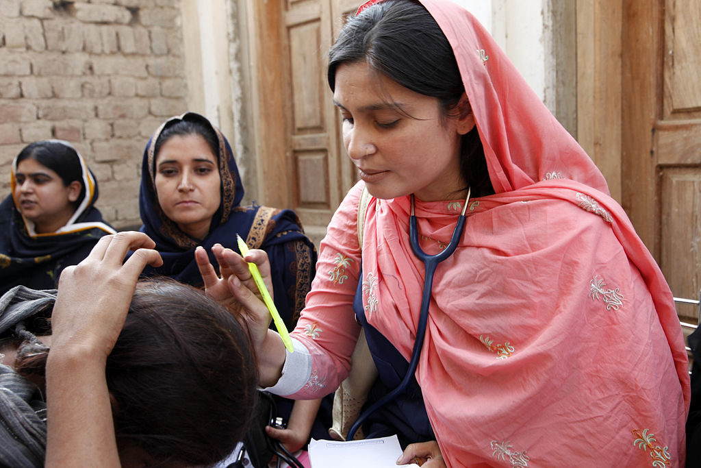 A female doctor in Pakistan examples a child, c. 2010. Courtesy of Department for International Development/Russell Watkins