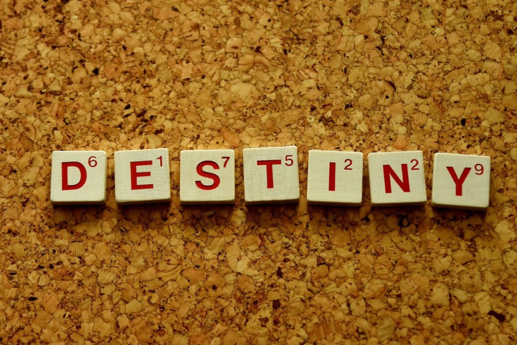 Tiles spell out "destiny" on a cork background.