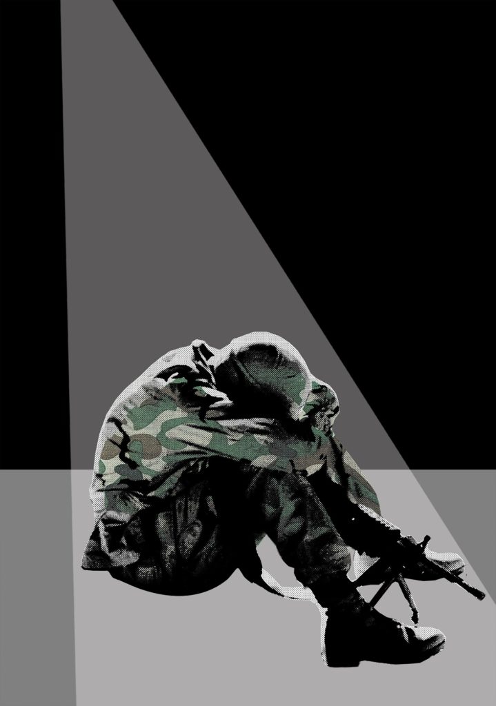 A seated soldier presses his face to his knees in despair.