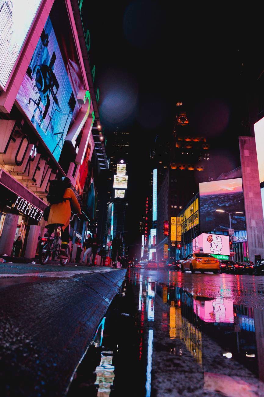 A New York City street near Times Square lit up in neon during the night.