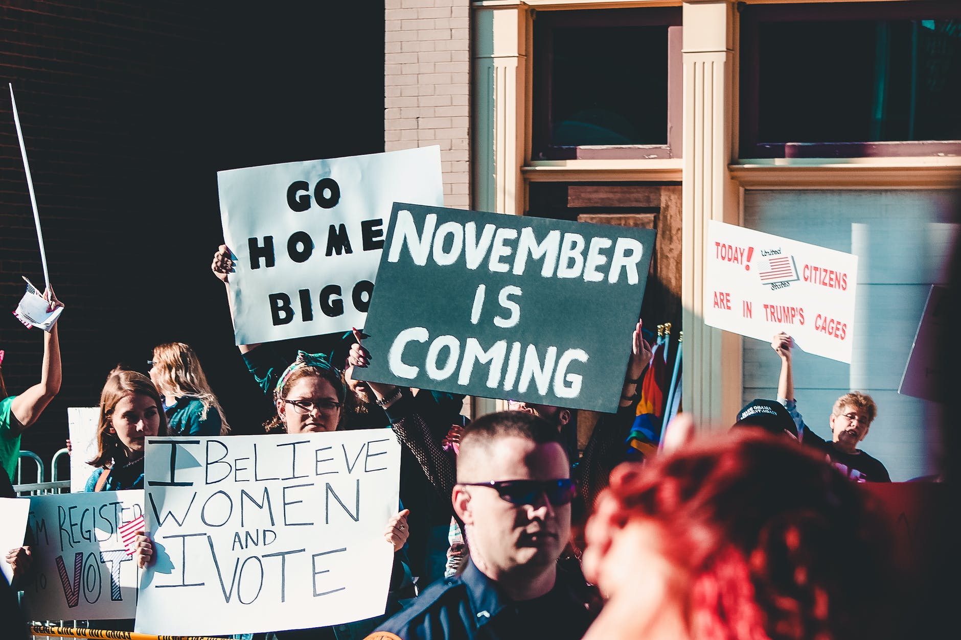 A crowd of people holding banners showing their political beliefs.